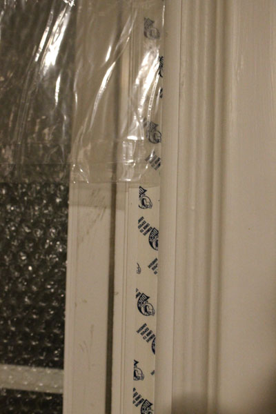Stick a length of the double-sided tape along the molding on either side of the glass.